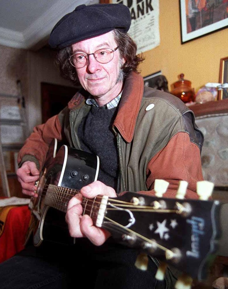 Noel Redding, former member of the Jimi Hendrix band, playing an acoustic guitar.