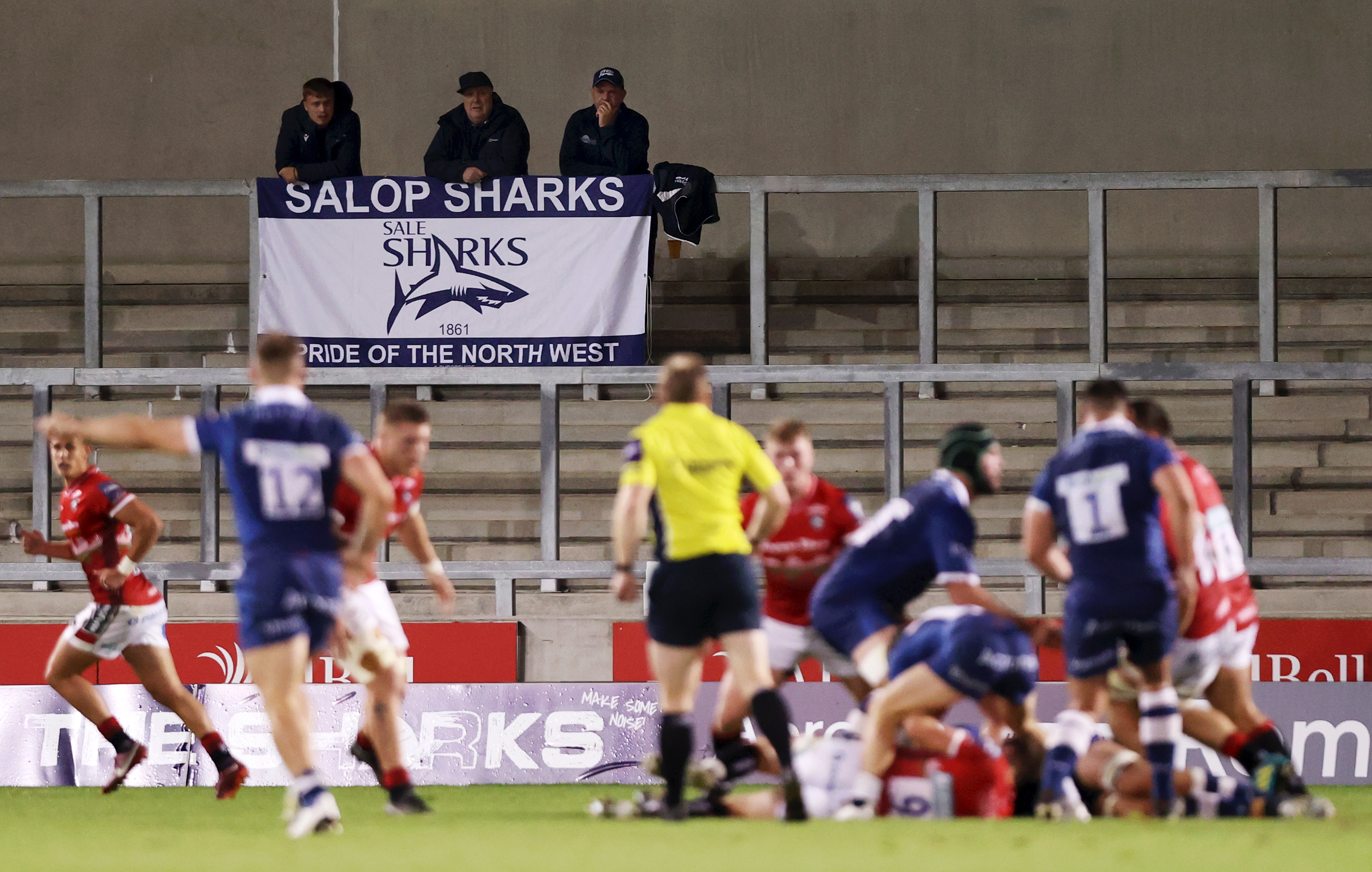 Rugby fans in the stands watch a match between Sale Sharks and Leicester Tigers.