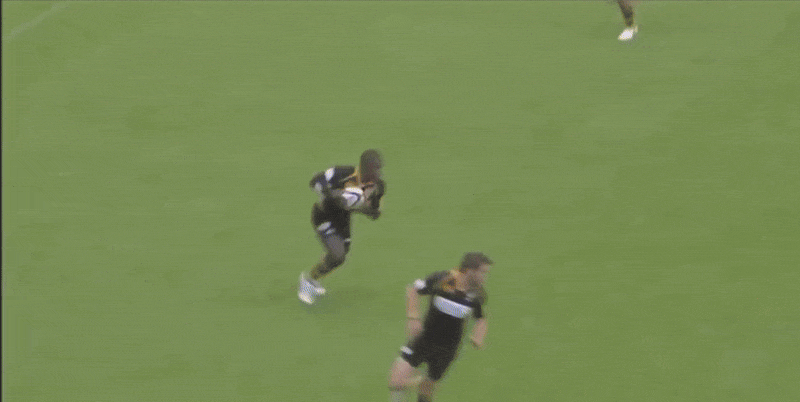 Rugby player Wade with the ball running down the field.