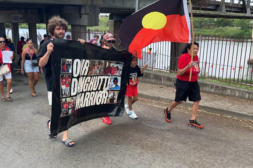Leetona Dungay holding an Indigenous flag during rally.