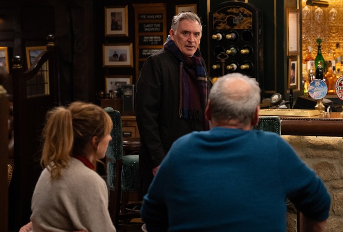 Bob stands in The Woolpack talking to Laurel and Jimmy in Emmerdale