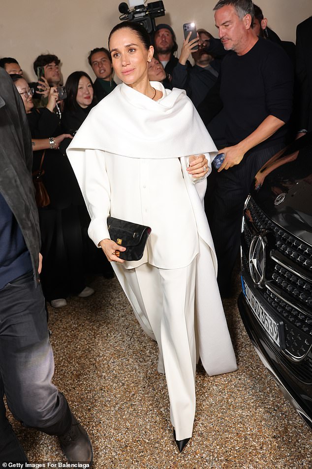 The Duchess of Sussex delivered a fashion moment in an all-white ensemble with black accessories during her unexpected appearance at the Balenciaga show at Paris Fashion Week
