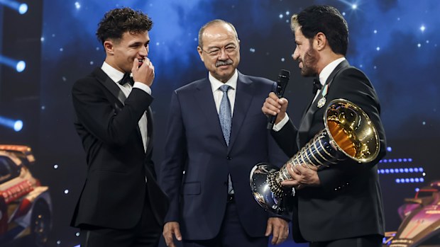 Lando Norris speaks with FIA President Mohammed Ben Sulayem before accepting the Formula 1 Drivers' Championship trophy.