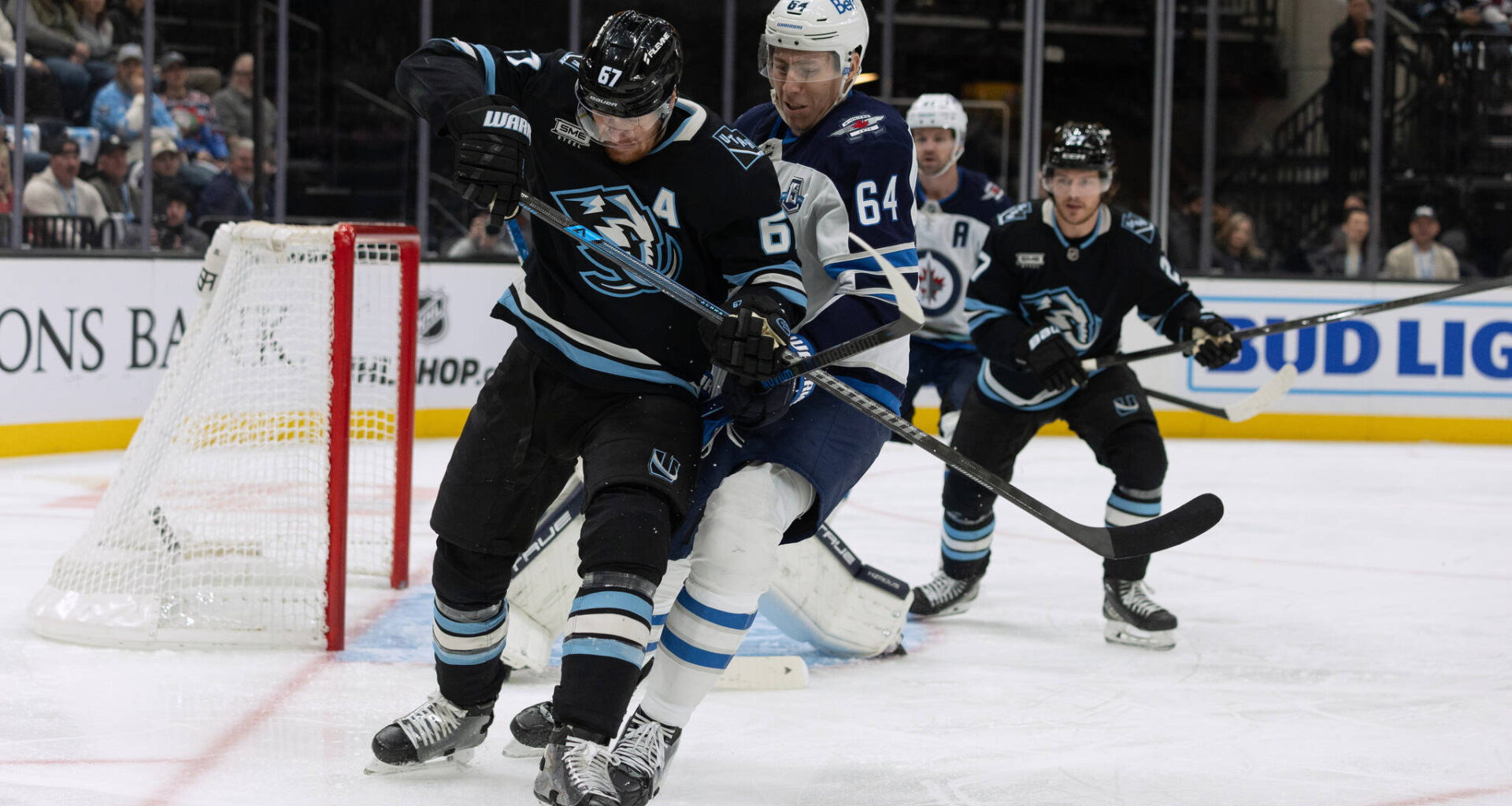 Utah Mammoth left wing Lawson Crouse, front, fights for the puck against Winnipeg Jets defenseman Logan Stanley (64) during the first period of an NHL hockey game, Sunday, Dec. 21, 2025, in Salt Lake City. (Melissa Majchrzak / The Associated Press)
