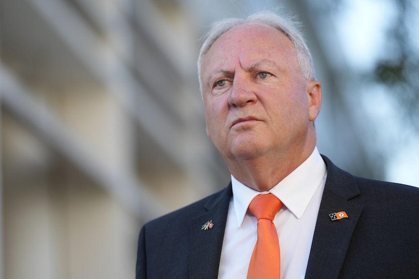 Steve Edgington wears a suit and tie while standing outside NT Parliament.