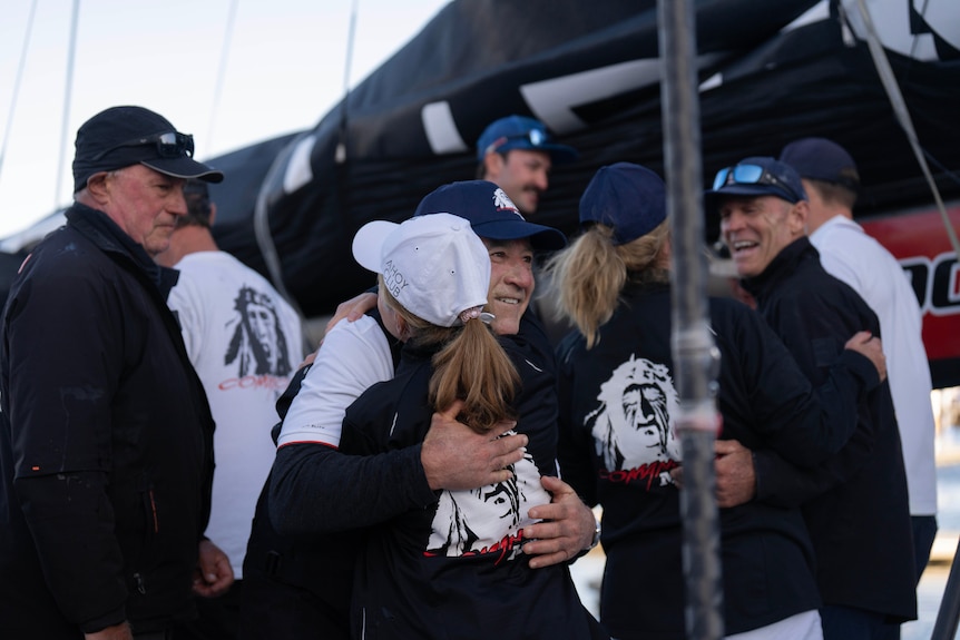 a man and woman embrace in a crowd