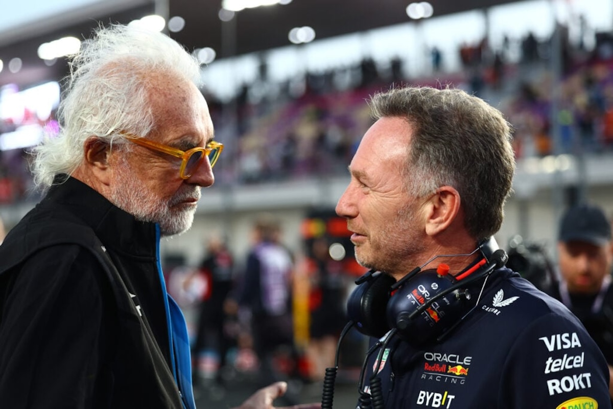 Two men, Horner and Briatore, conversing at a racetrack.
