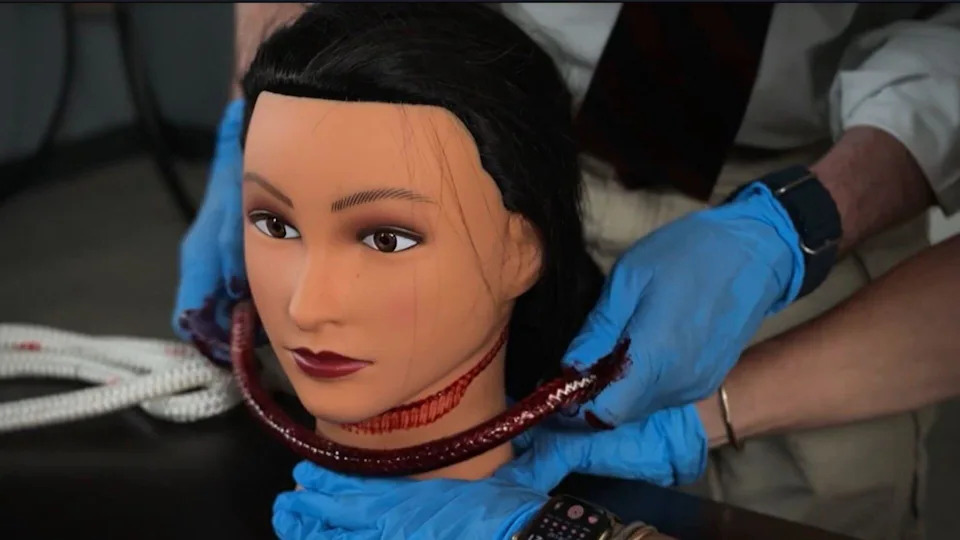 Using a mannequin and red paint, Dr. Bill Smock demonstrates the pattern of ligature marks found on Joanna Hunter's neck during her autopsy. / Credit: CBS News