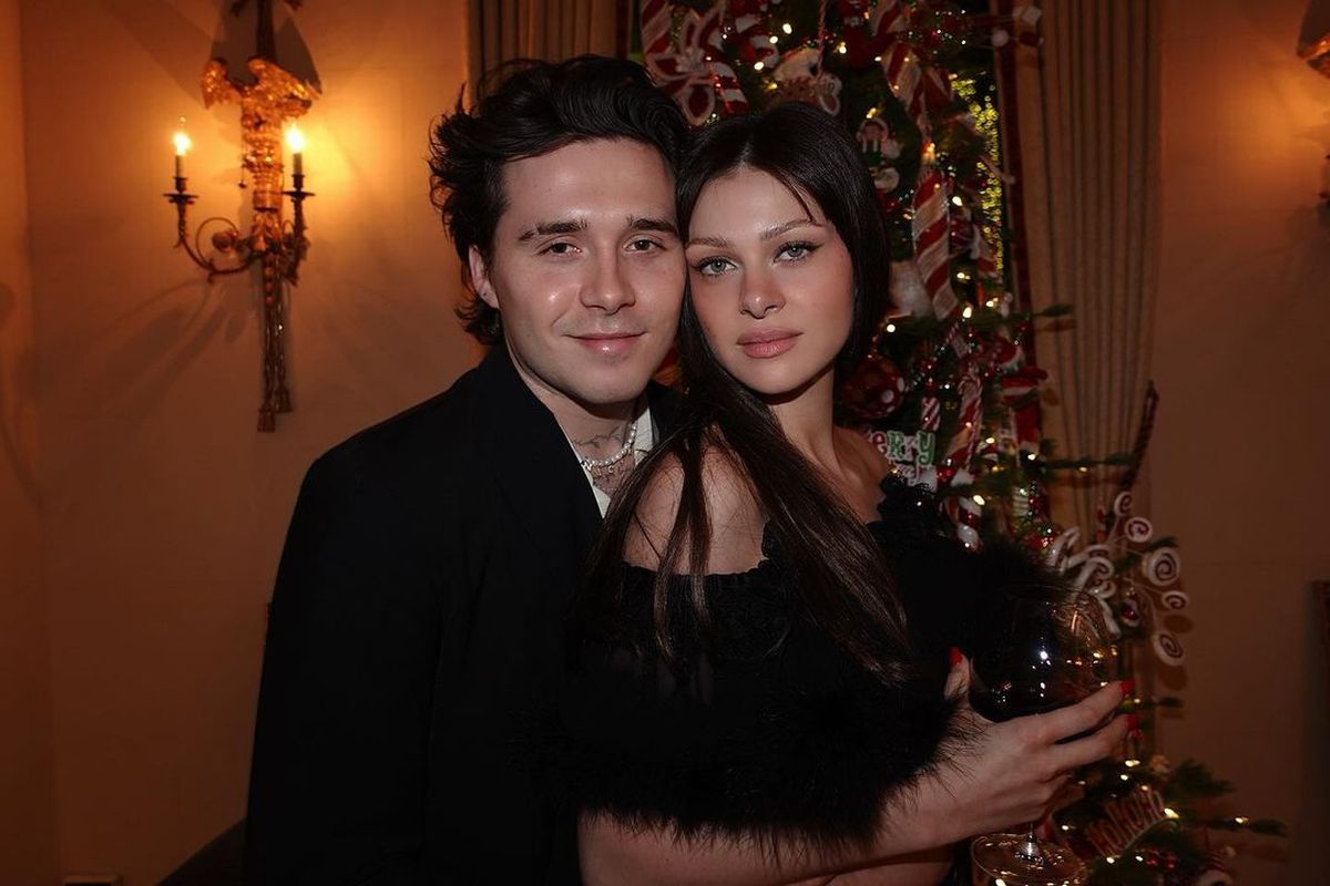 Brooklyn Beckham and Nicola Peltz hugging each other and dressed in black