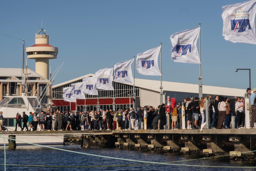 crowds stand on a dock