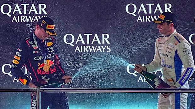 Winner Red Bull driver Max Verstappen of the Netherlands, left, and third placed Williams driver Carlos Sainz of Spain celebrate on the podium after the Qatar Formula One Grand Prix, in Lusail, Qatar, Sunday, Nov. 30, 2025.(AP Photo/Fatima Shbair)
