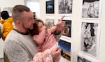 The son and granddaughter of photographer Ann Kendellen enjoy an image of themselves on display at Blue Sky's First Thursday event. December 2025.