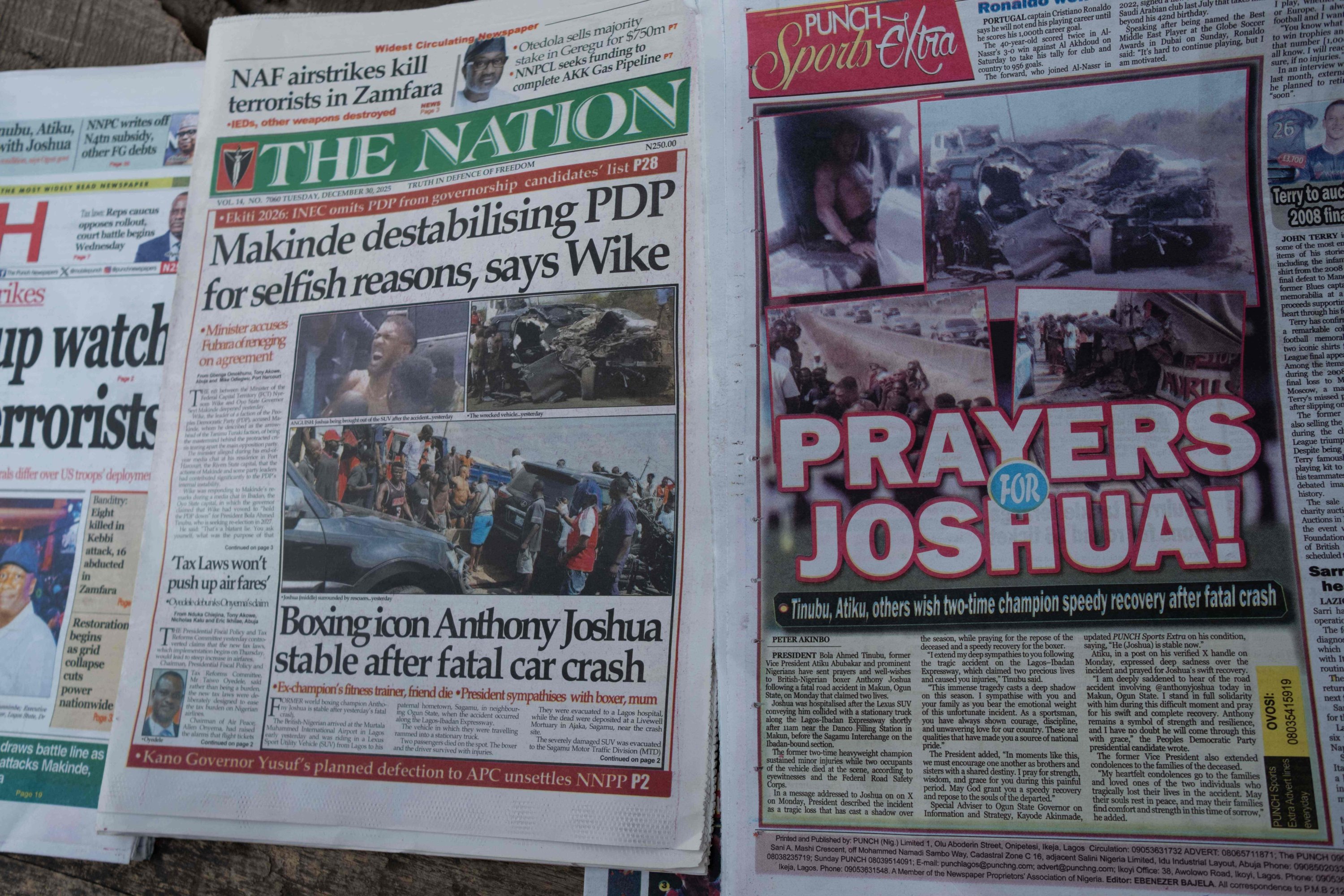 Newspapers bearing headlines about a road accident involving British boxer Anthony Joshua, who was hospitalized in stable condition after a crash that killed two people, are displayed at a stall, Abeokuta, Nigeria, Dec. 30, 2025. (AFP Photo)