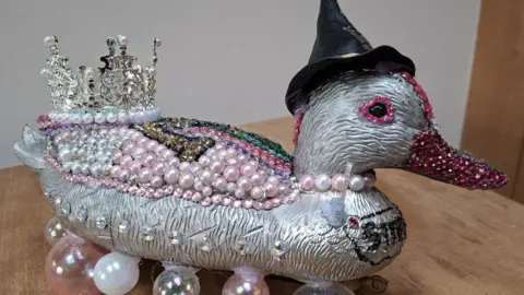 Kenilworth Lions Club A silver plastic duck decorated with pink beads, glitter and a silver crown