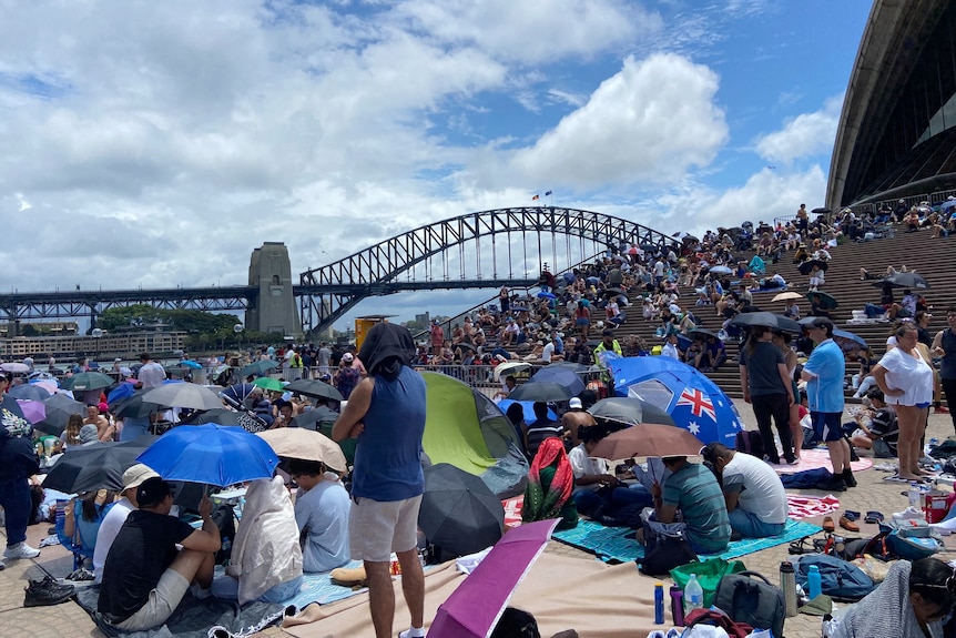 Crowd packing an area in the background Sydney harbour bridge