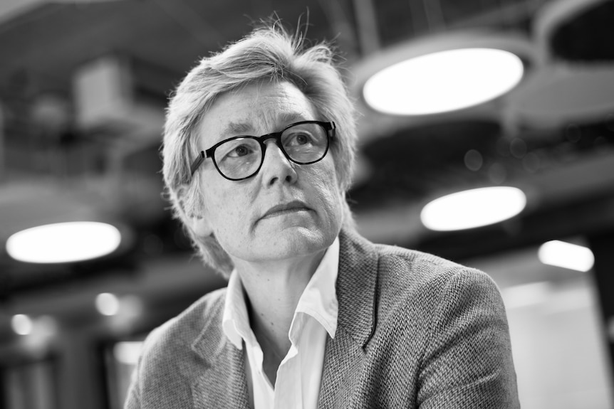 A black-and-white photo of a middle-aged woman looking pensively to the side.