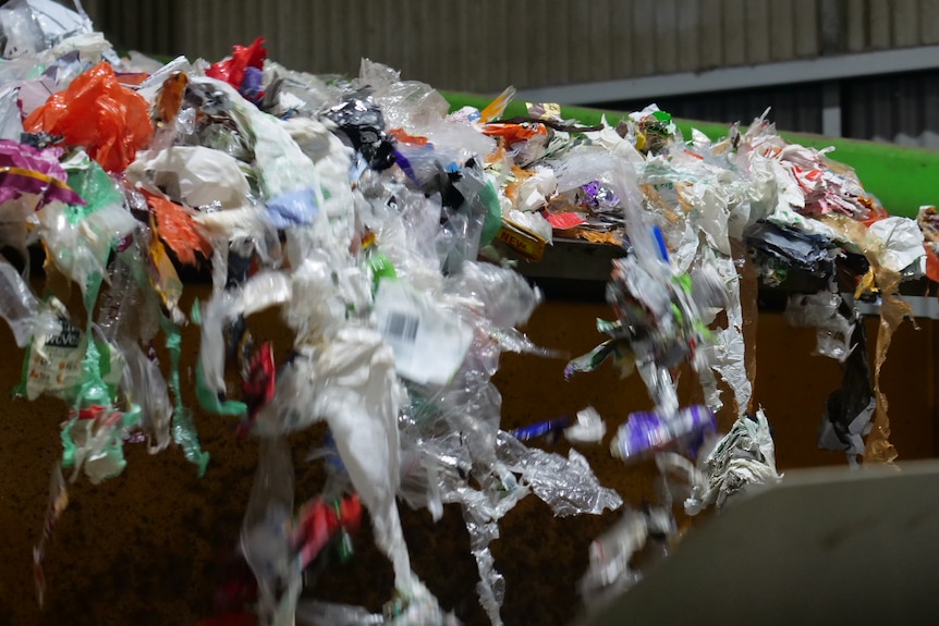 Shredded soft plastic on a conveyer belt.