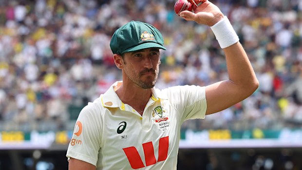 Mitchell Starc of Australia holds the ball aloft after taking 7 for 58