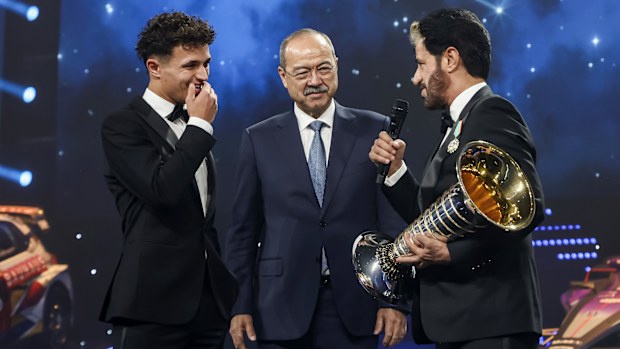 Lando Norris speaks with FIA President Mohammed Ben Sulayem before accepting the Formula 1 Drivers' Championship trophy.