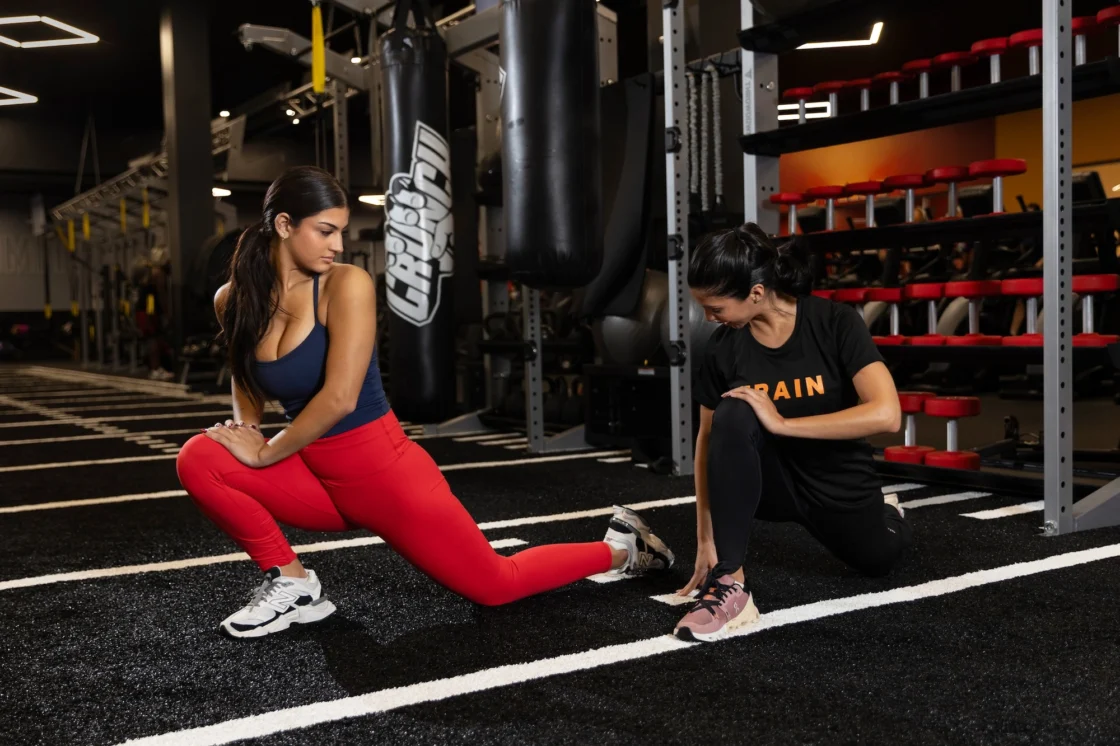woman works out with a trainer at Crunch Fitness