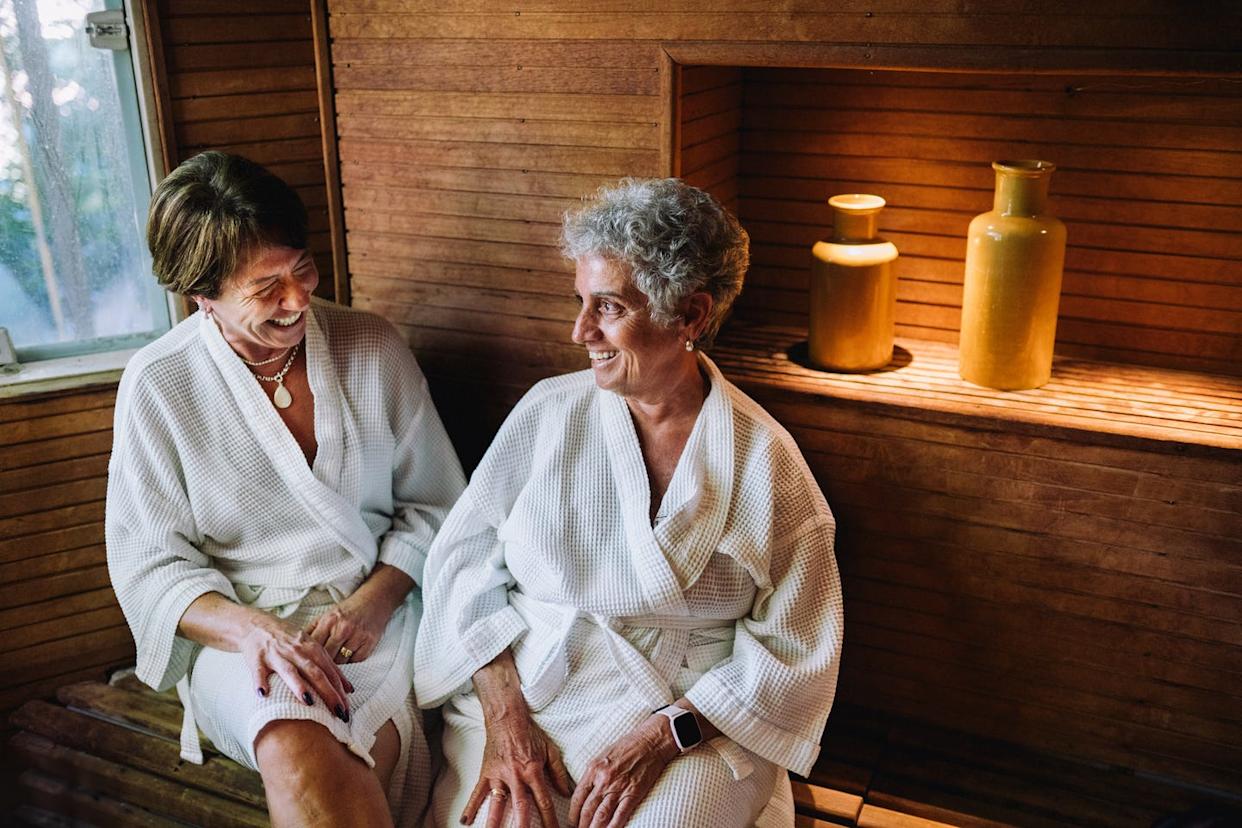 two mature women inside a sauna having conversations in a spa