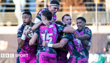 Six Ospreys players in a huddle celebrating scoring a try in their win at Montauban in the Challenge Cup