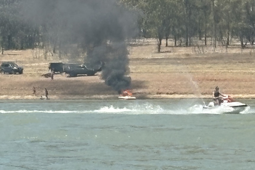 A boat on fire on a lake