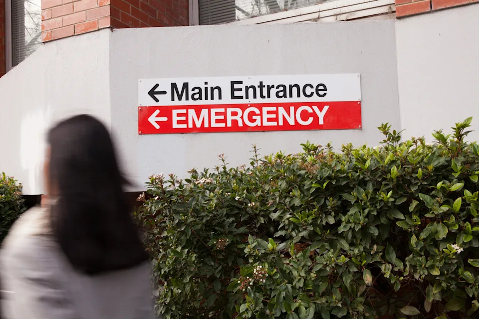A woman hurries to the emergency entrance to the hospital.