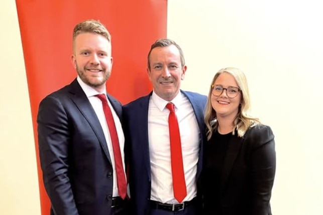 Tim Picton, Mark McGowan and Ellie Whiteaker stand with their arms around each other.