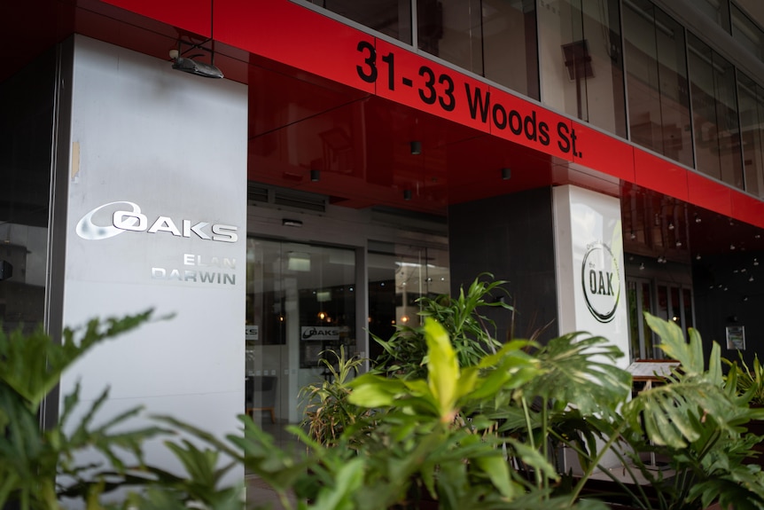 An exterior image of Oaks sign on walls in front of foliage.