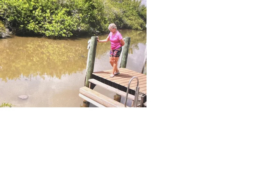 Mitzie Norman watches raw sewage drift past her home along Turkey Creek in Palm Bay. Untold volumes of raw sewage spilled from a broken sewer pipe near the city's main sewer plant off Clearmont Street late Sunday. City officials were still trying to stop the spill Monday.