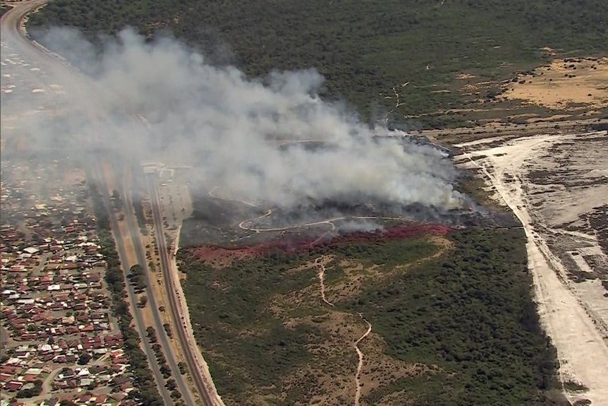 Smoke billows towards a suburban neighbourhood