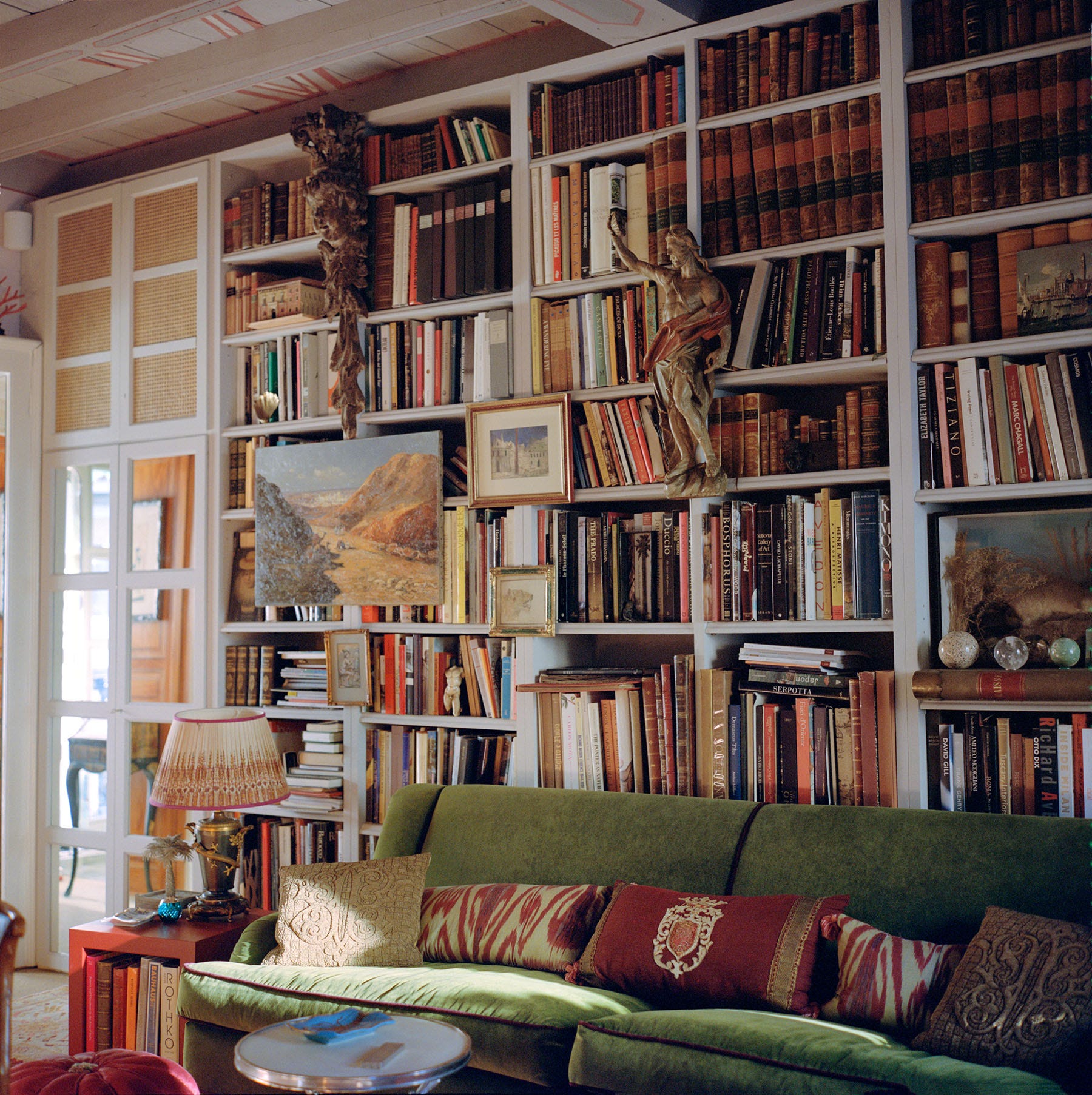 Living room with a green sofa, bookshelf, and decorative elements.