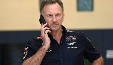 Horner in Red Bull kit looking down at his phone