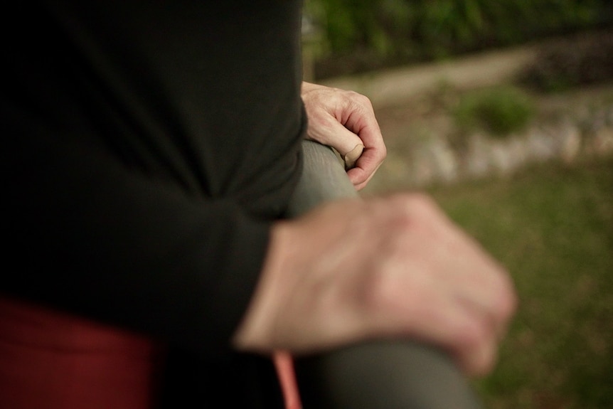 A close-up of a woman's hands on a balcony railing.