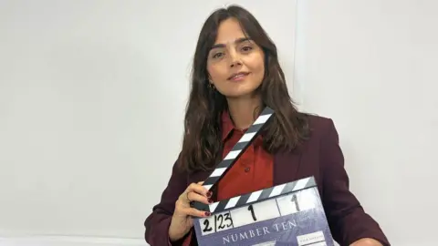 Hartswood Films/Channel Four Jenna Coleman carrying a clapperboard for the Number 10 production