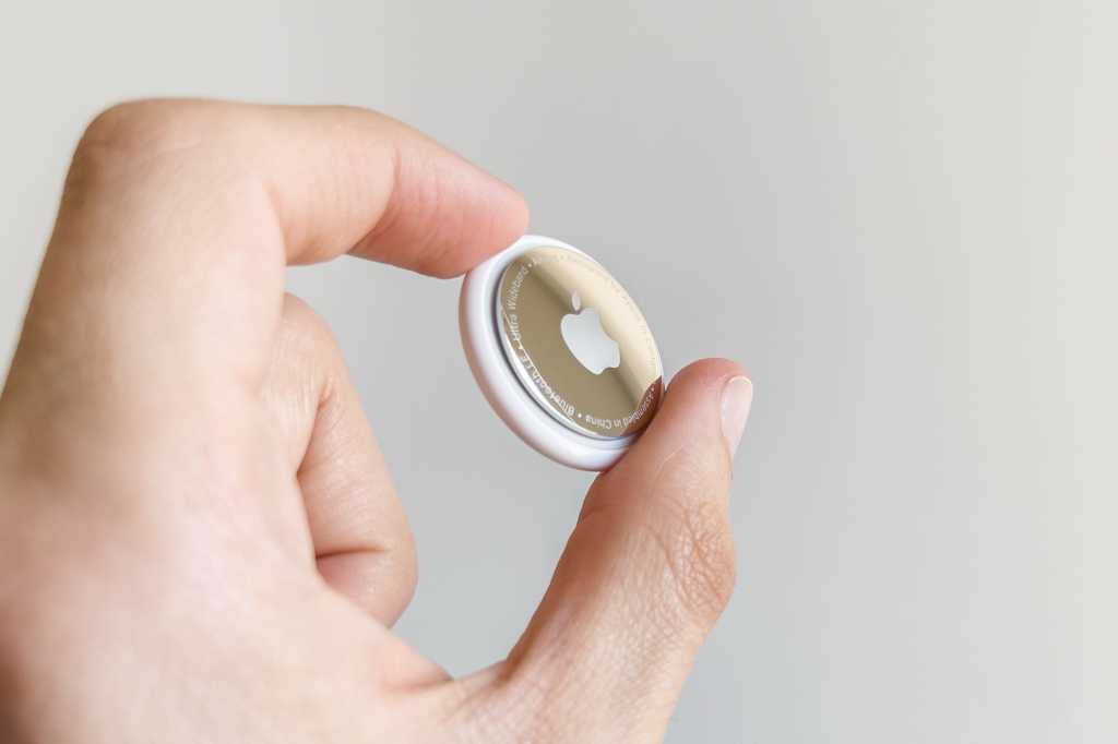 pesona holding an AirTag tracker