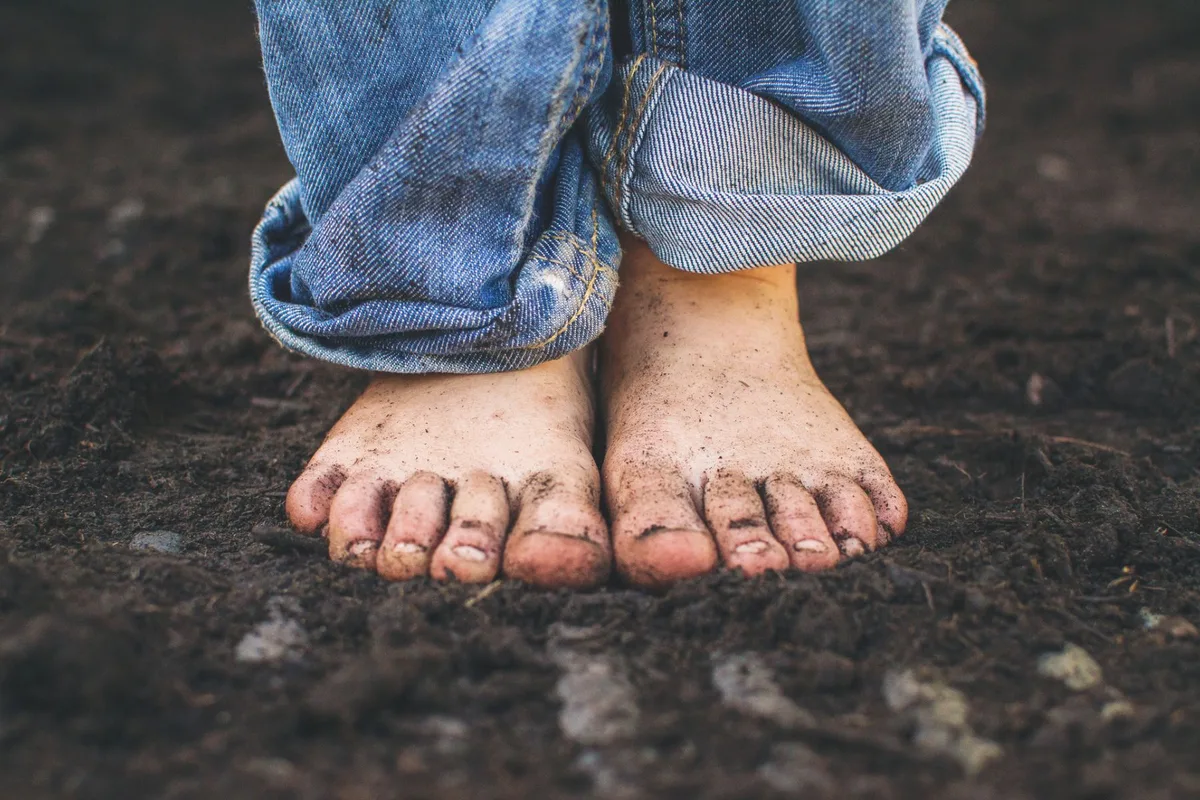 A pair of bare feet stood in soil