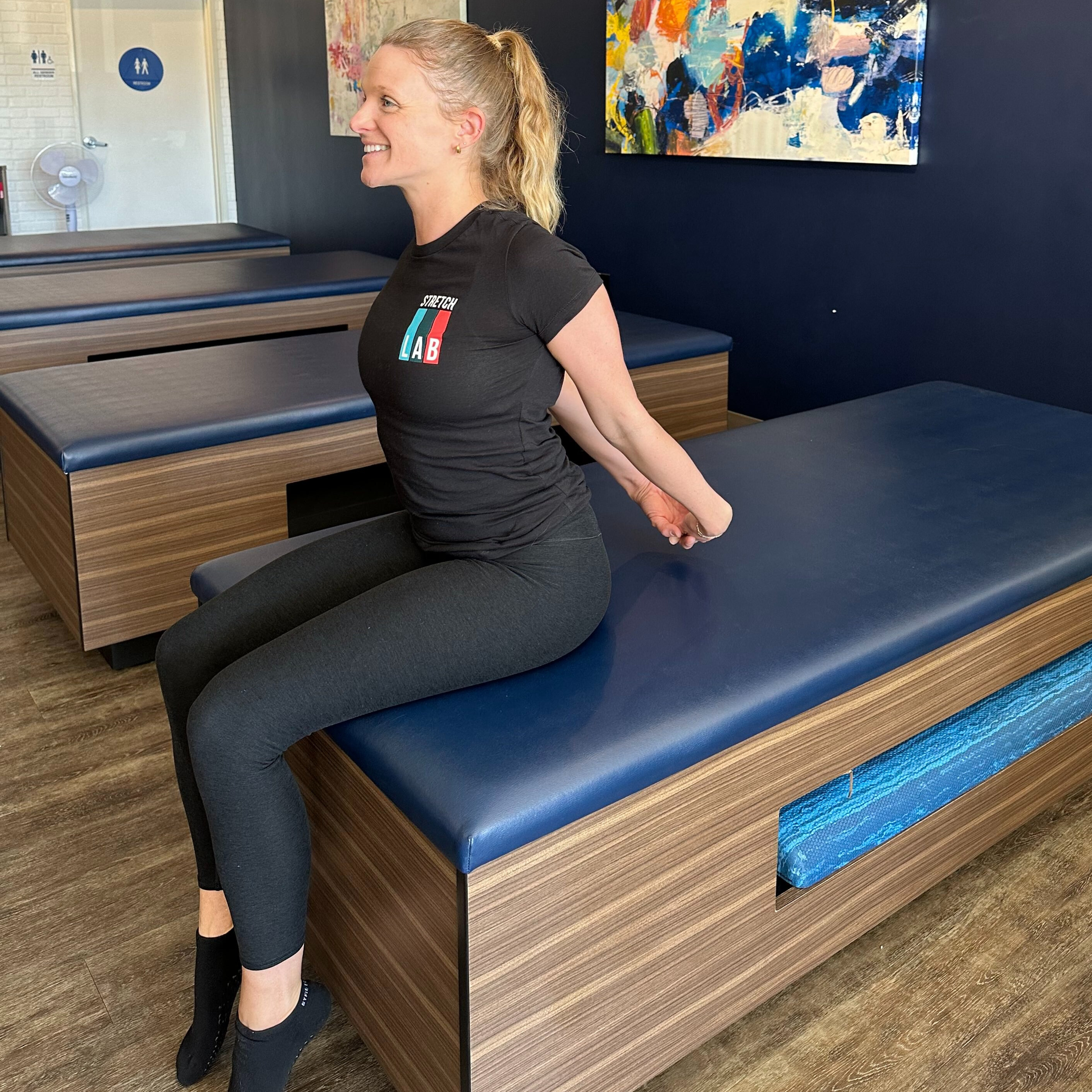 Woman demonstrates stretch in fitness studio