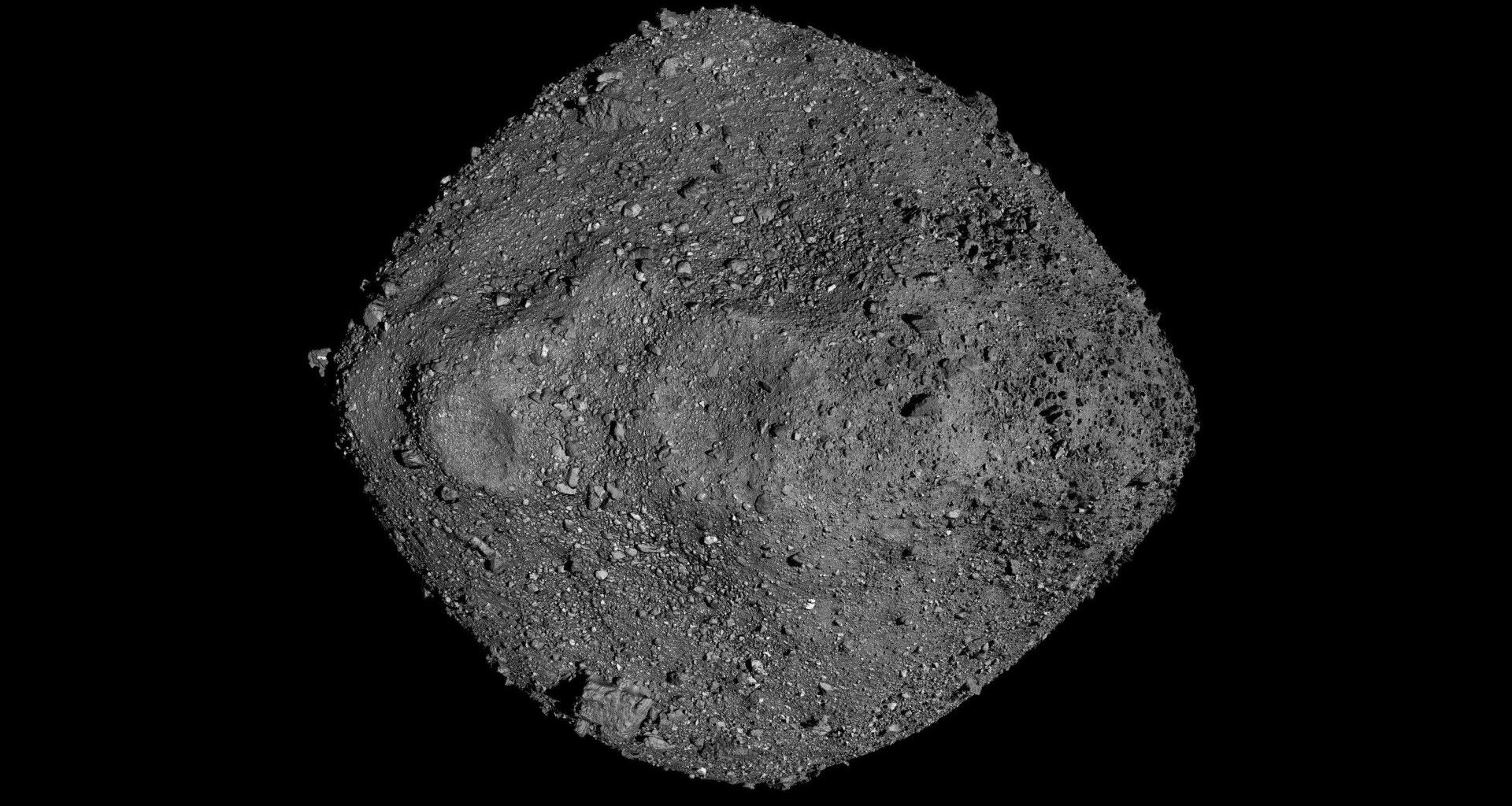 a ball of grey boulders and rocks seen against the blackness of space