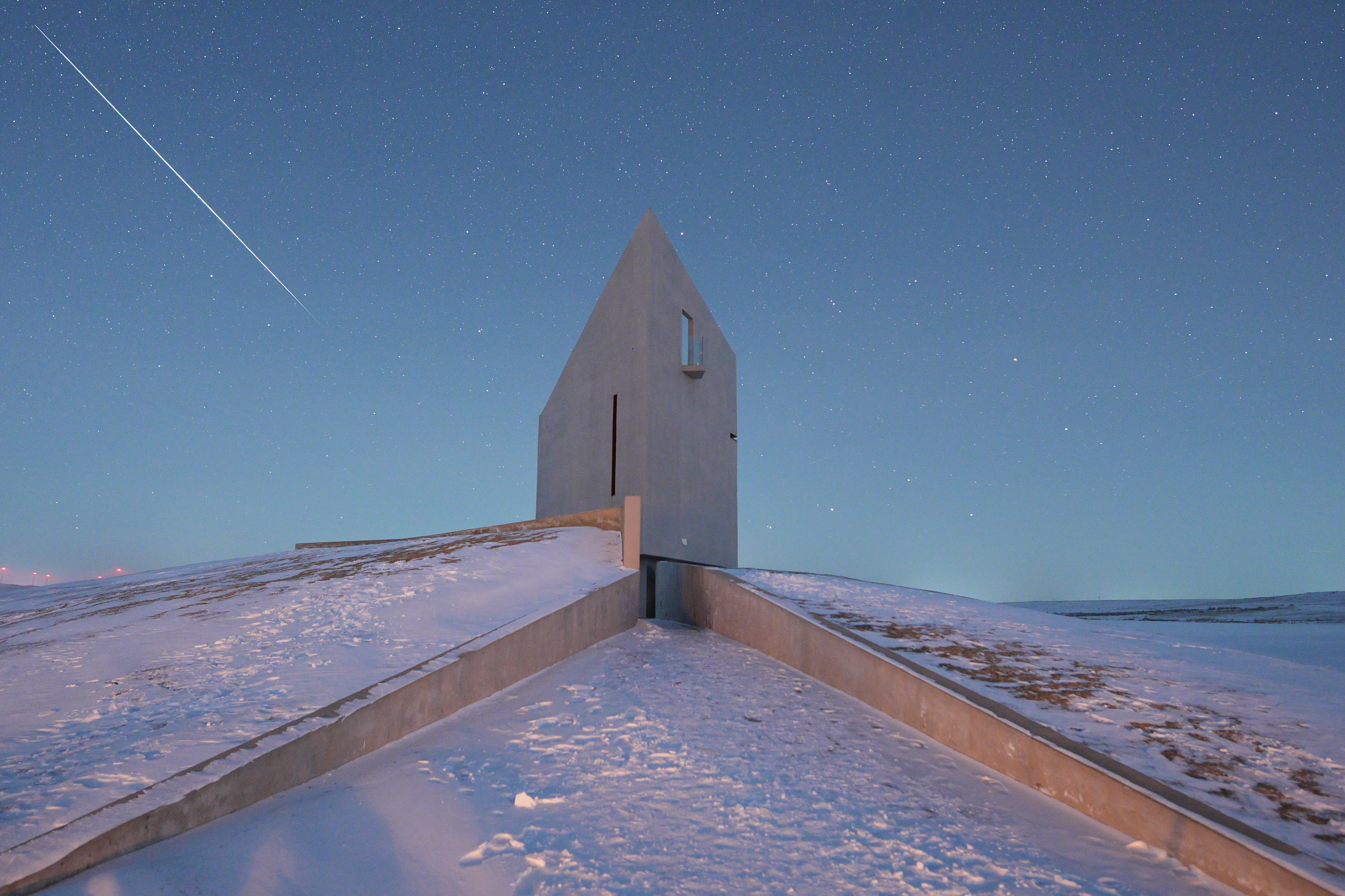 A photo of a Geminids meteor streaking above a building in Inner Mongolia.