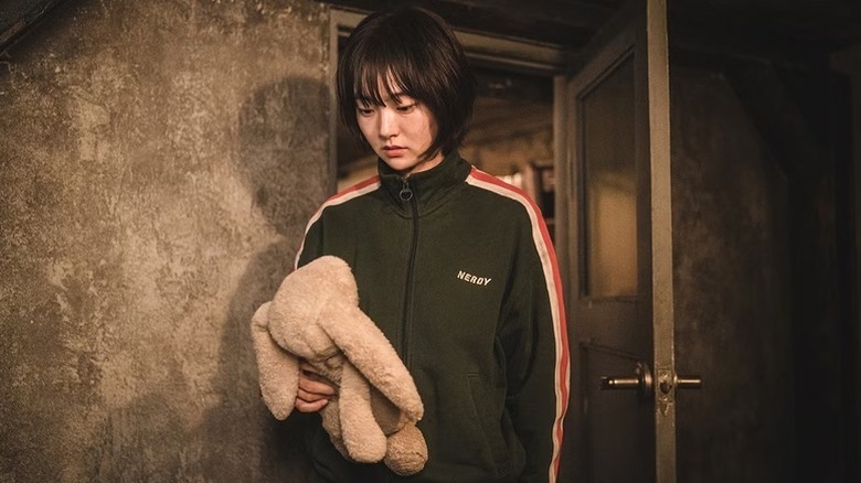 Jeong Ji-an (Kim Hye-jun) examines a stuffed animal in A Shop for Killers
