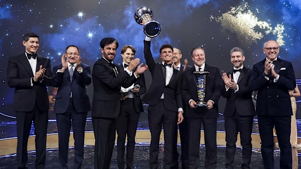 Lando Norris raises the Formula 1 Drivers' Championship trophy at the FIA gala awards.