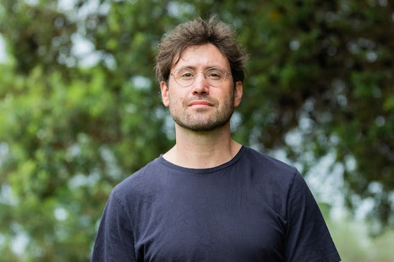 Joe Rafalowicz wears a dark blue t-shift and glasses.