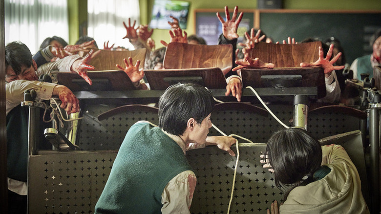 Students barricade themselves behind desks and chairs from zombies on All of Us Are Dead