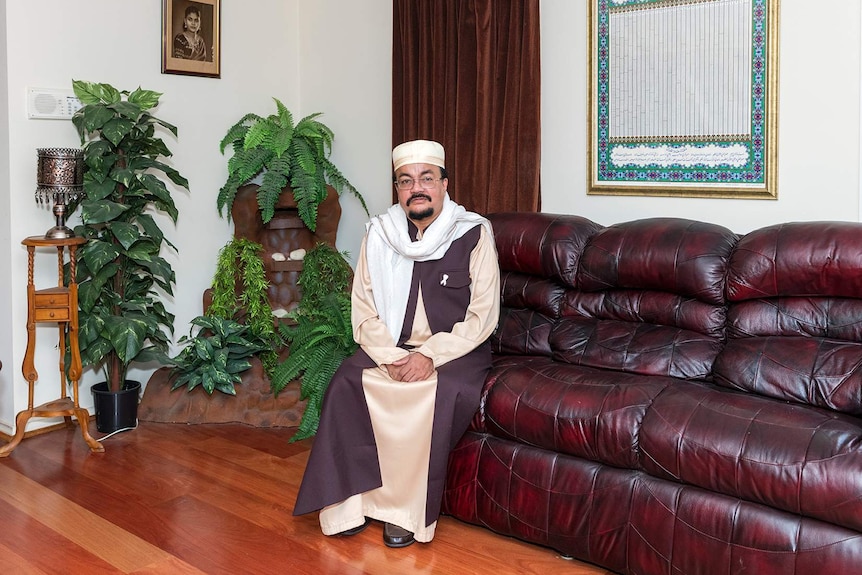 A man sitting on a sofa next to house plants