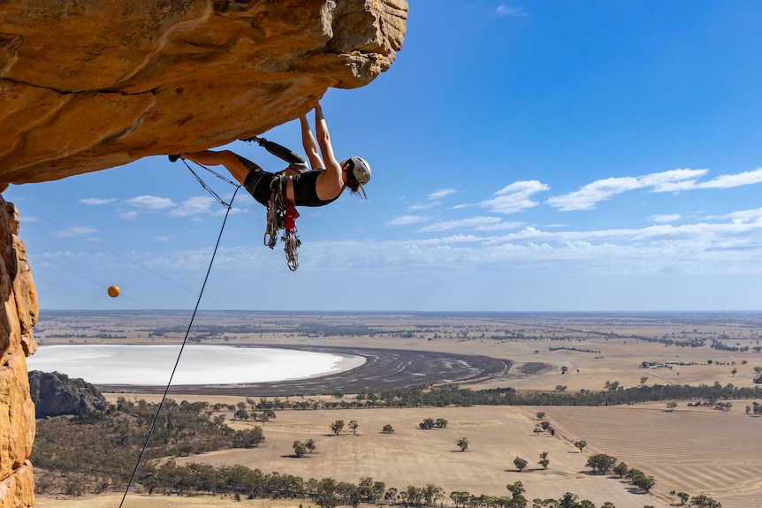 Sarah Larcombe hanging from a roof on the Kachoong route at Mount Arapiles.