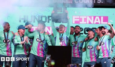 Sam Billings lifts The Hundred trophy surrounded by his Oval Invincibles team-mates.