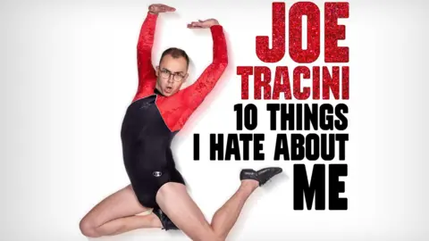 Joe in a leotard on a poster advertising his tour, called 10 things I hate about me. The leotard is black and has red sleeves. His legs are bare and he is wearing black lace-up dance shoes. 