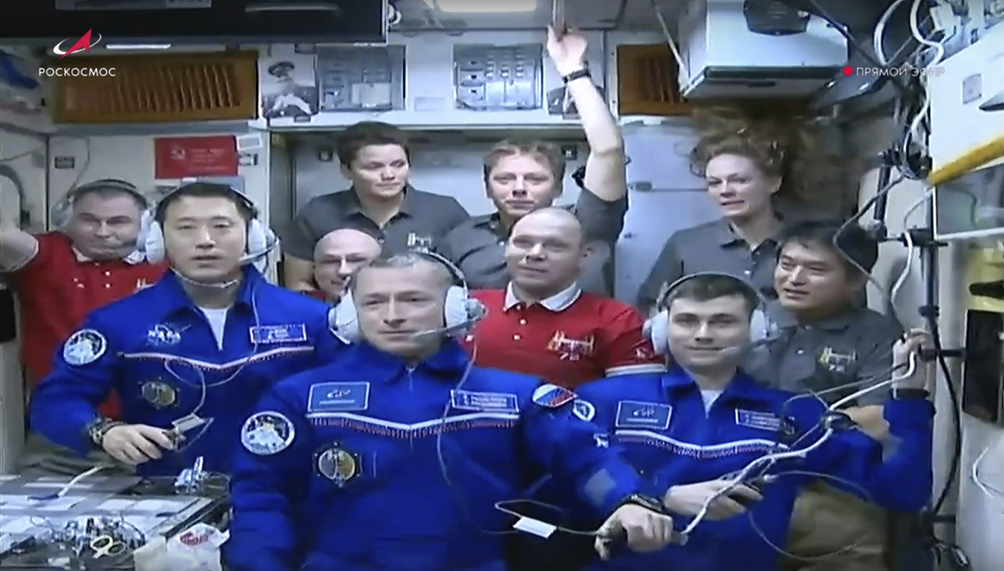 Wearing blue suits, NASA astronaut Jonny Kim, left, Roscosmos cosmonauts Sergey Ryzhikov, center, and Alexey Zubritsky pose among other participants of the expedition to the International Space Station (ISS) after docking the Soyuz MS-27 spaceship to the station on April 8 in this photo taken from video footage released by the Roscosmos Space Agency. [AP/YONHAP]